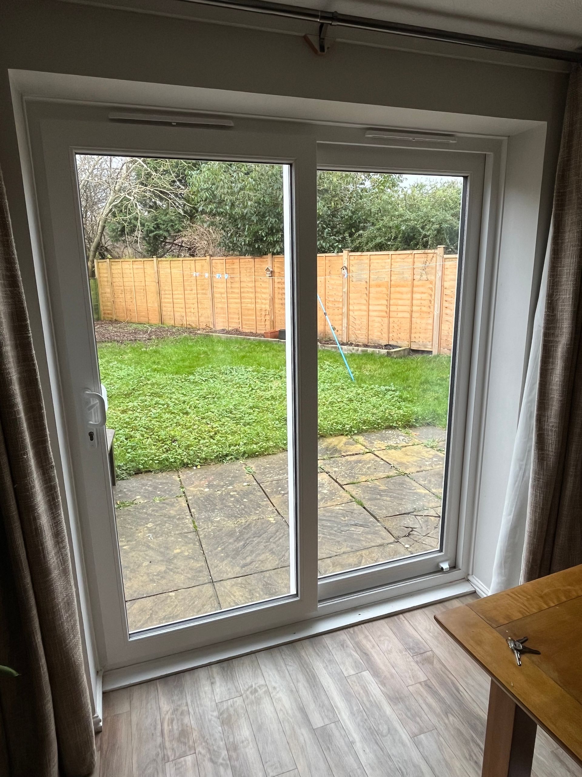 A living room with a sliding glass door leading to a backyard.