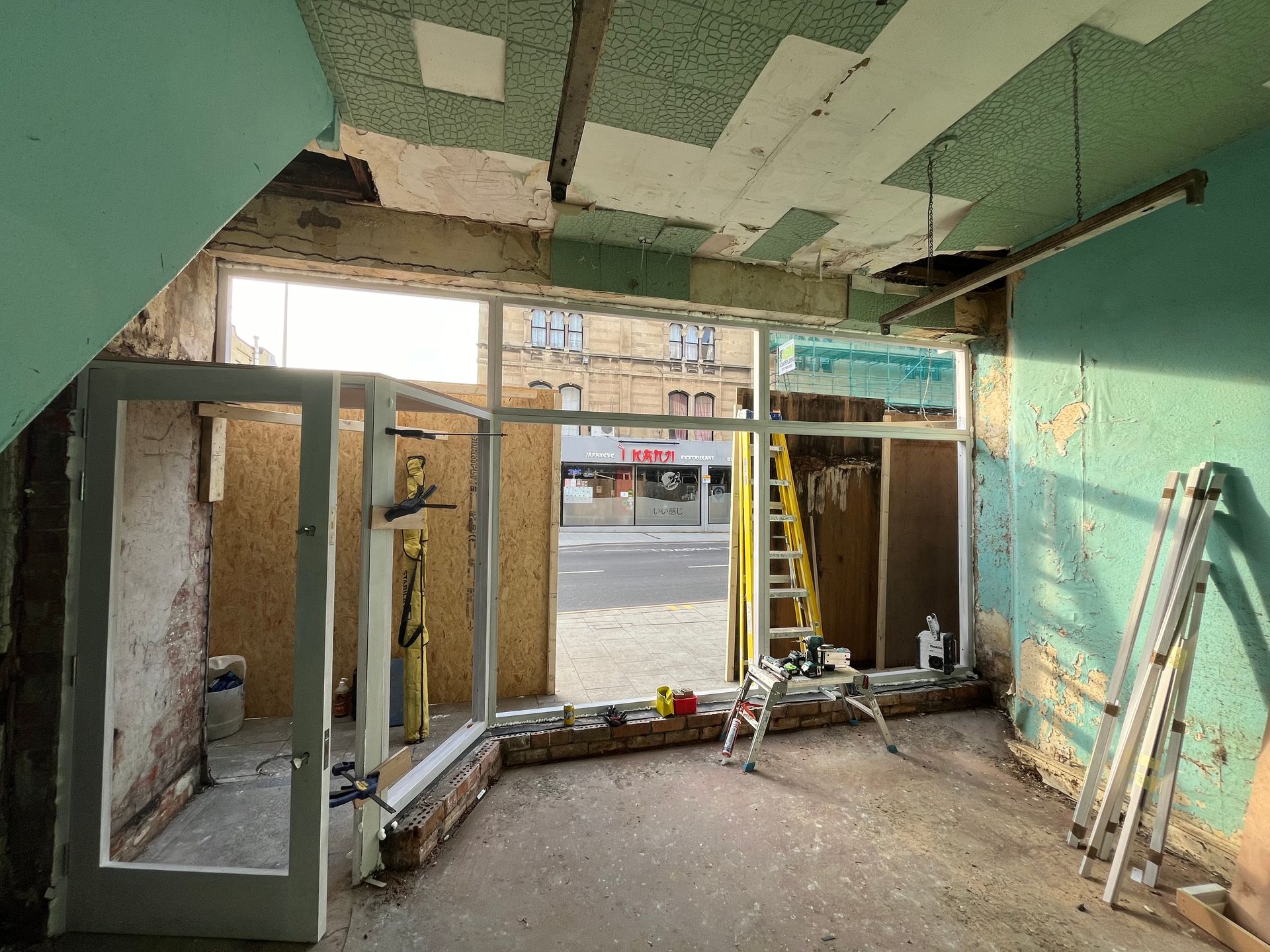 A room with a lot of windows and a ladder in it