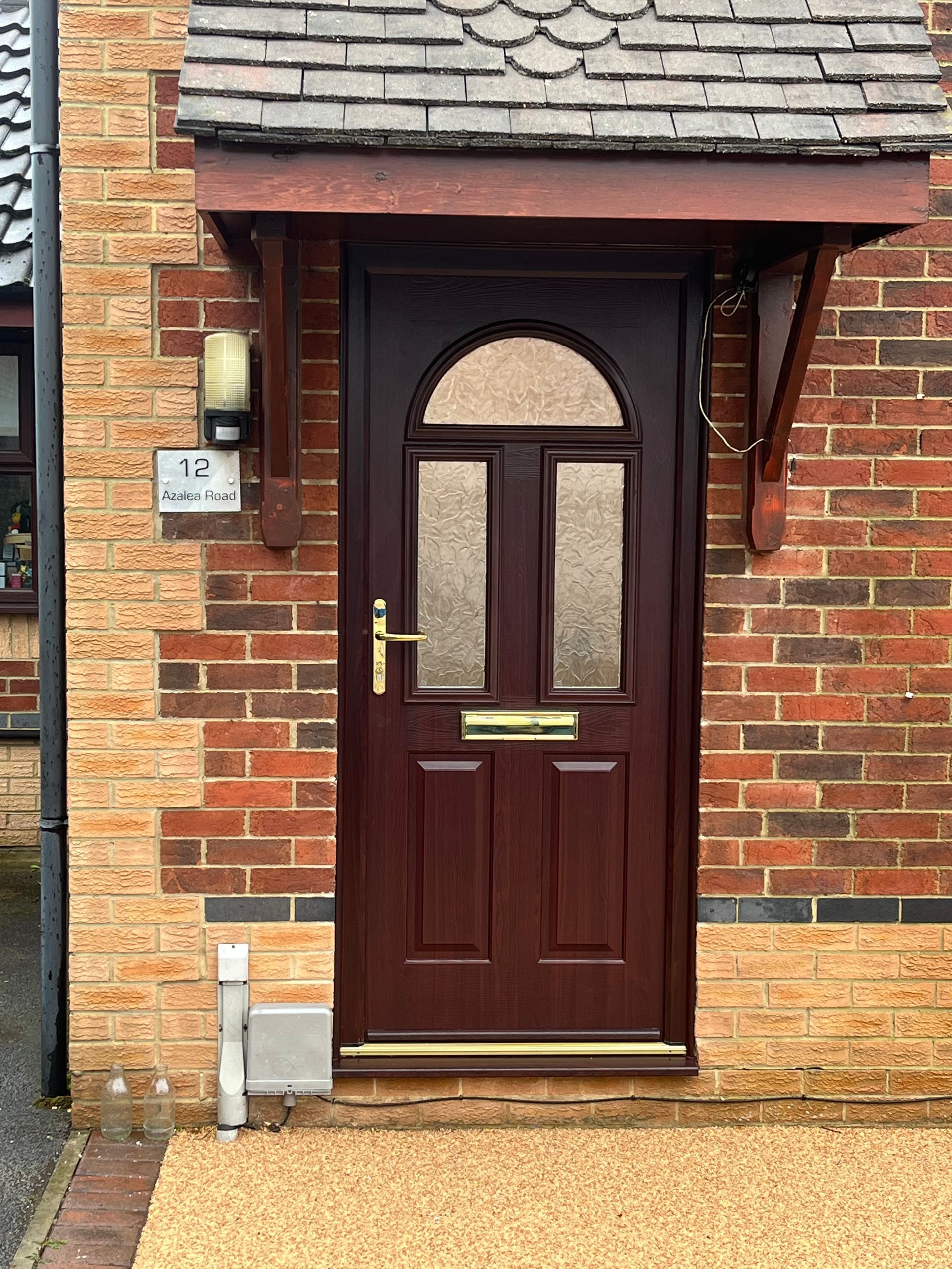The front door of a brick house has a canopy over it.