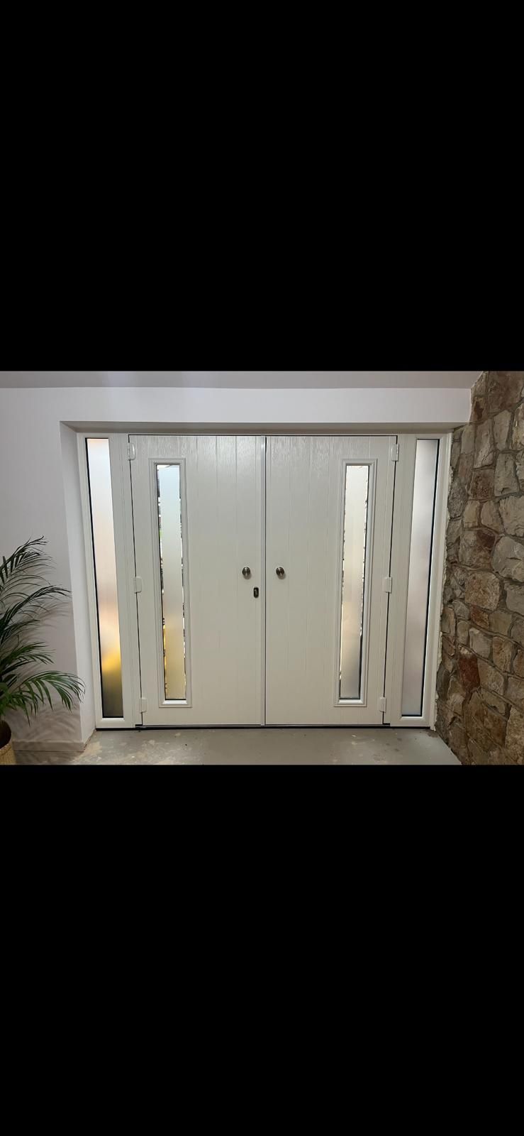 A large white door with a lot of windows in a room.