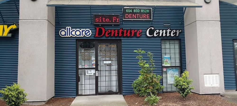 All Care Denture Center storefront with a blue facade, red and white lettering, and glass door.