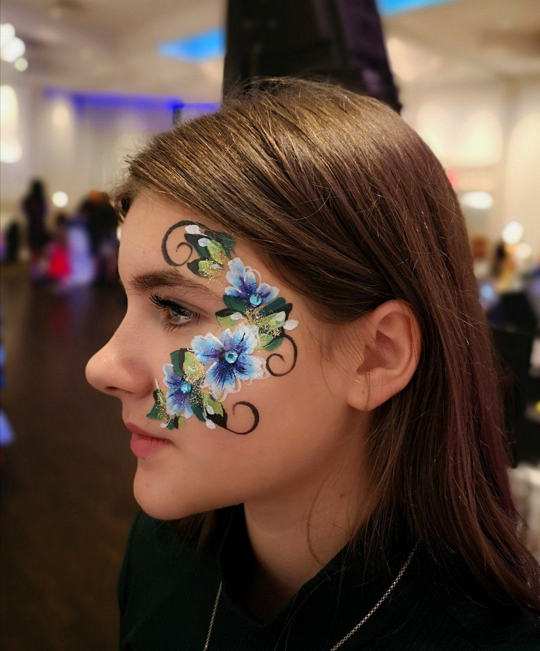 Flower face paint design near the eyes for kids and adults. Corporate event