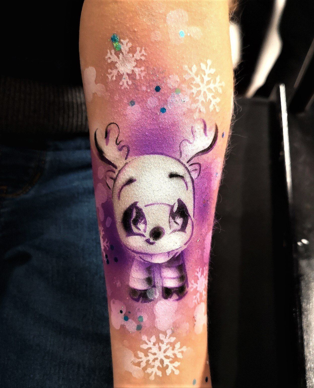Winter holidays event entertainment idea. Art on skin - airbrush temporary tattoo. Reindeer airbrush art
