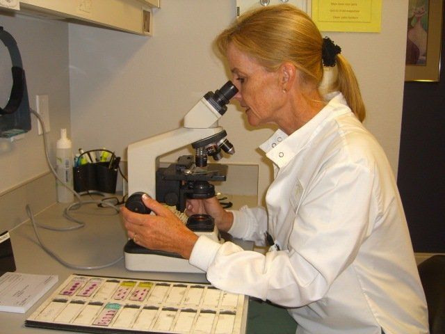 dermatologist looking through microscope - Mohs Surgery