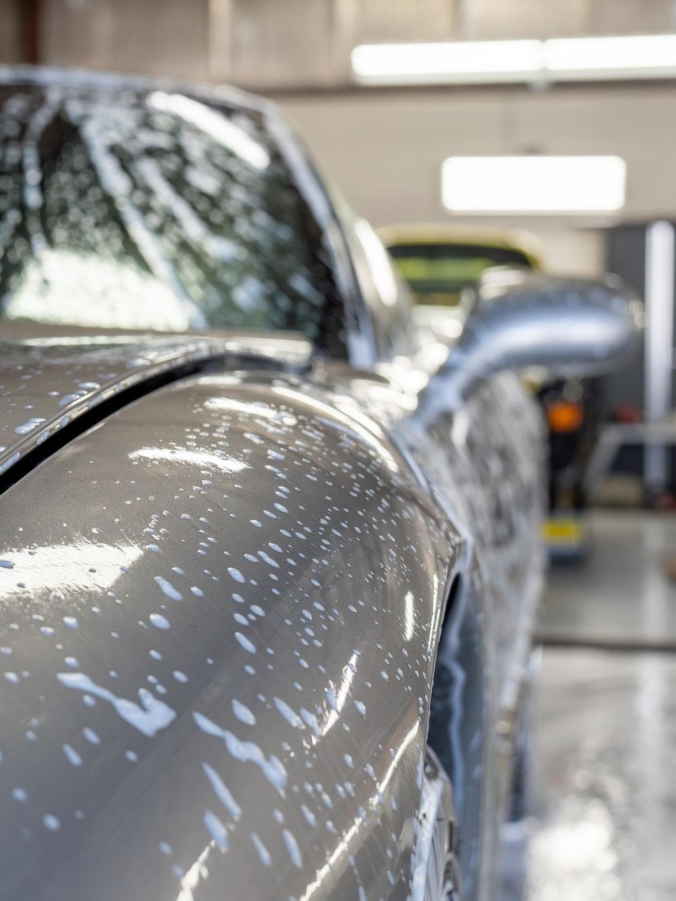 A close up of a car being washed in a garage