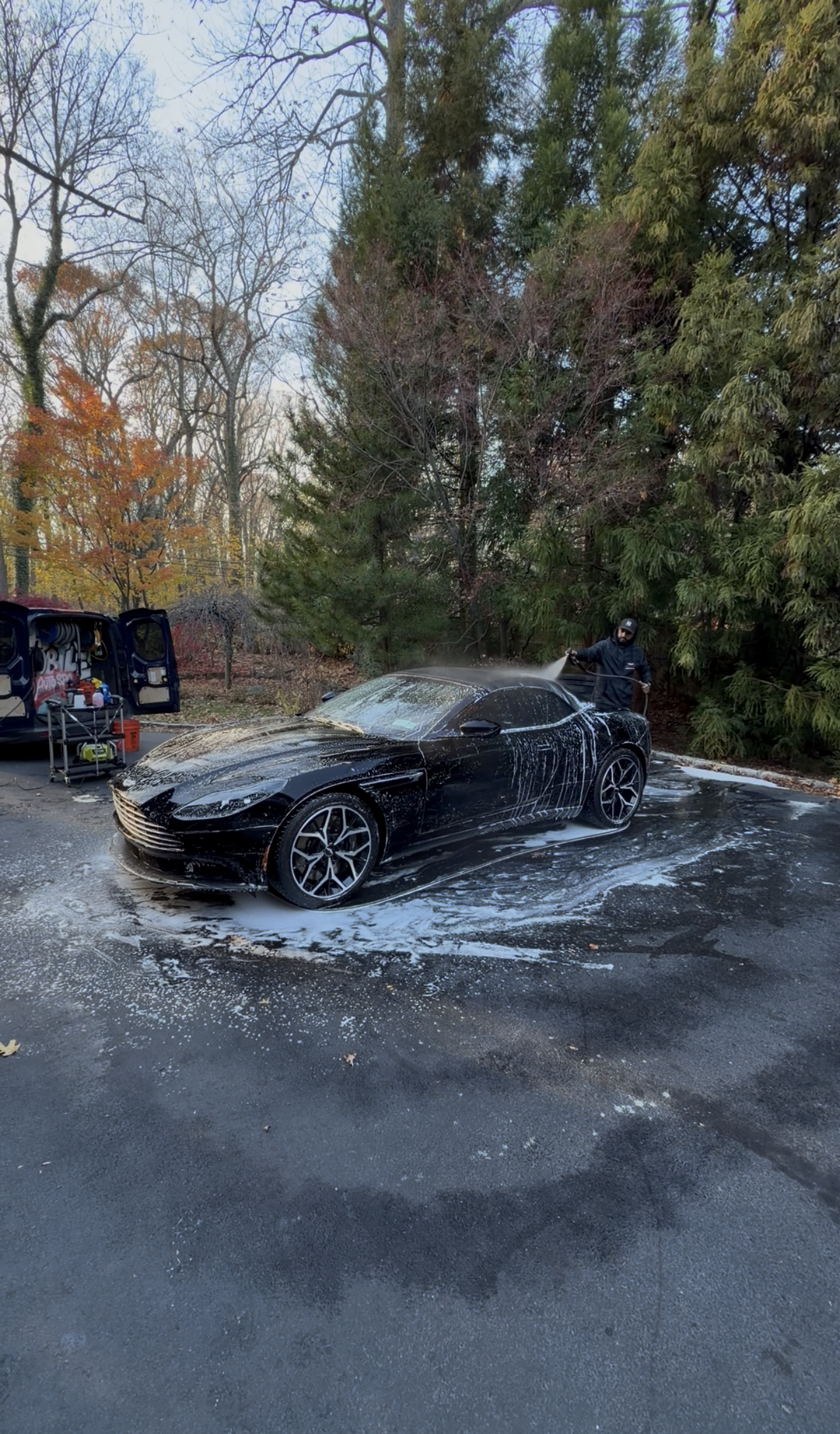 A man is wrapping a car with plastic wrap.