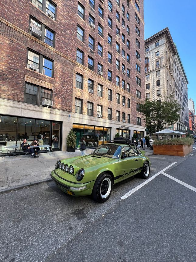A white range rover is parked on the side of the road