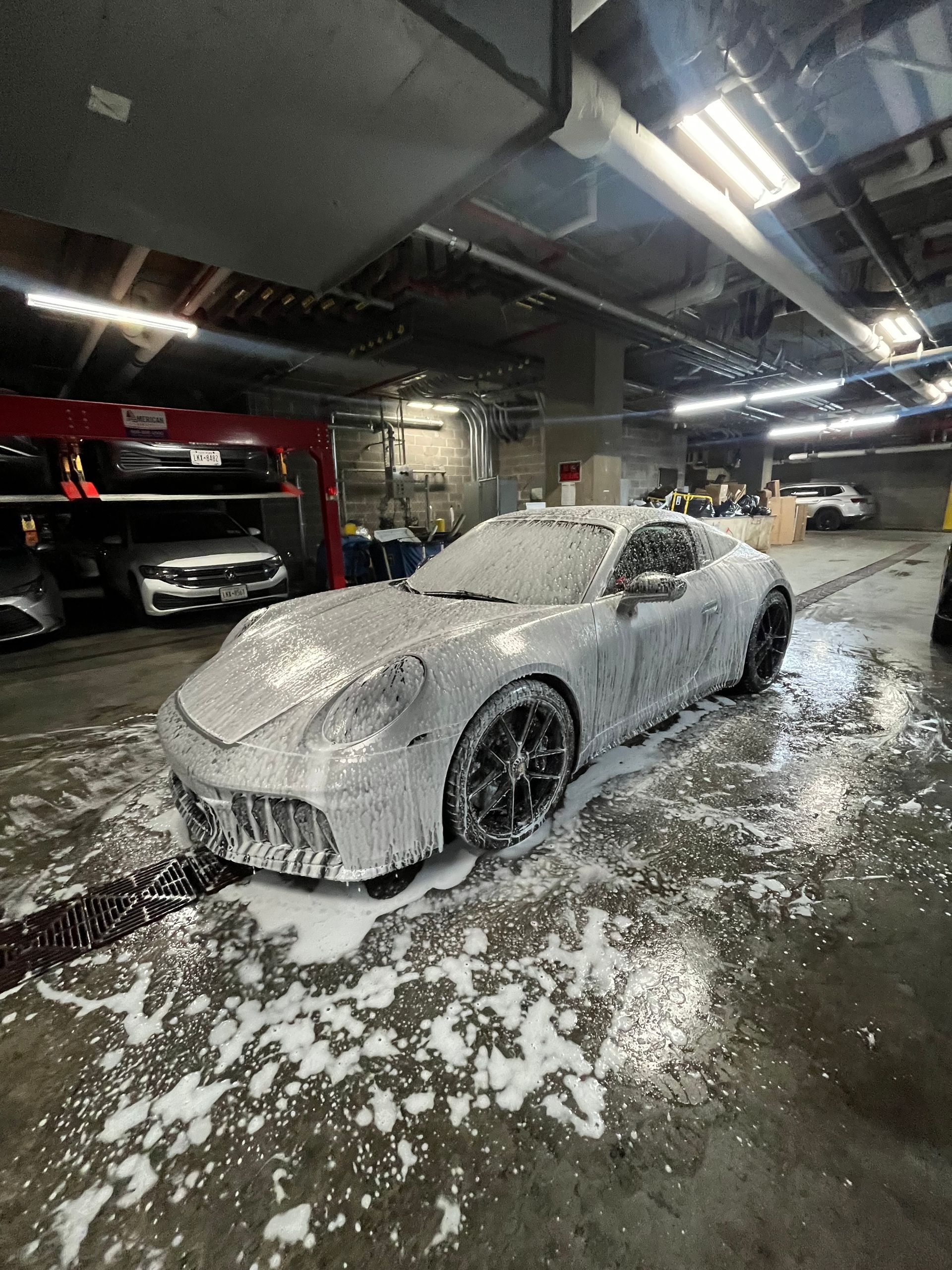 A light blue tesla model 3 is parked in a garage.