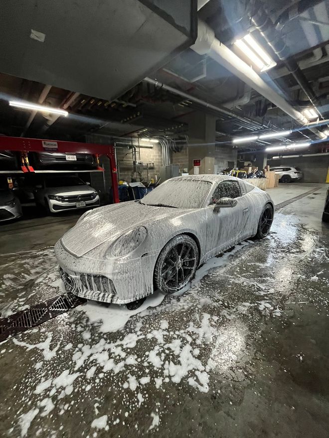 A light blue tesla model 3 is parked in a garage.