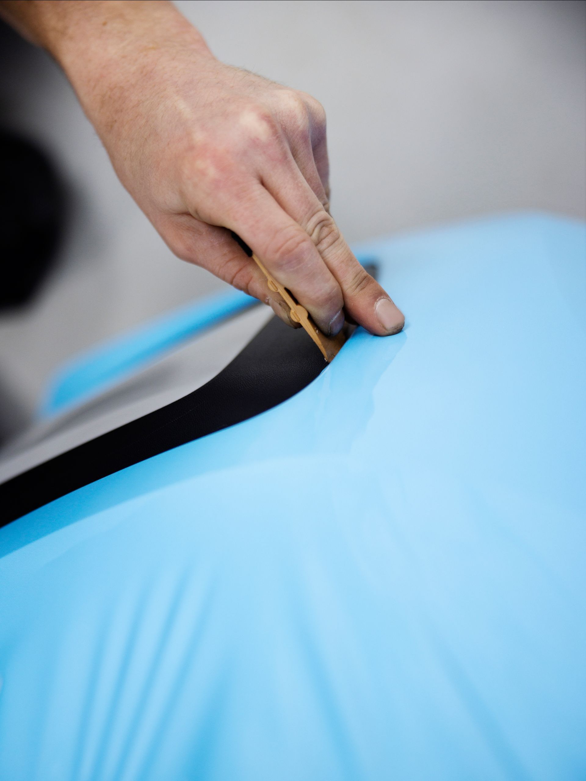 A person is cutting a piece of blue fabric with a pair of scissors