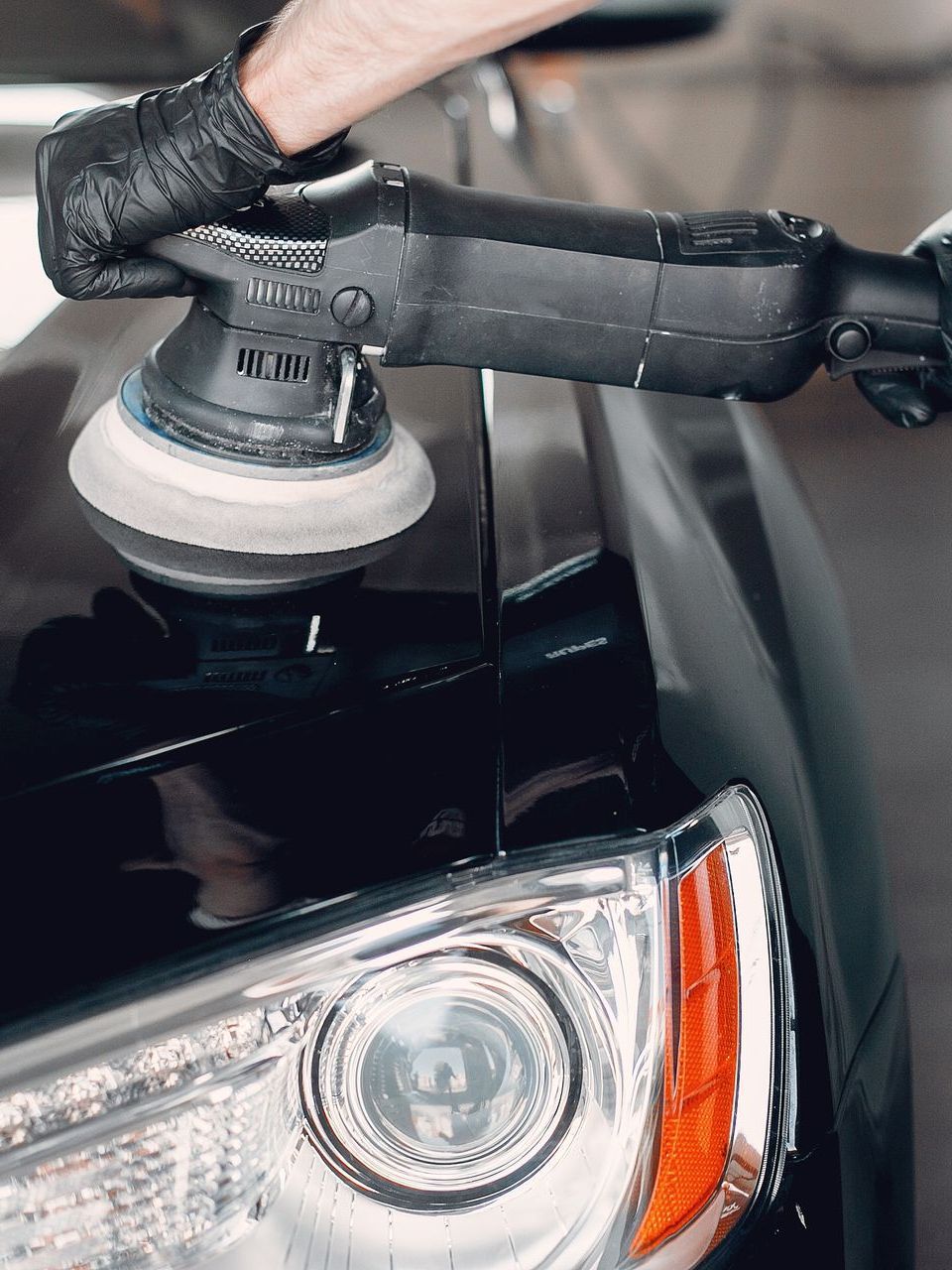 A person is polishing a car with a machine.
