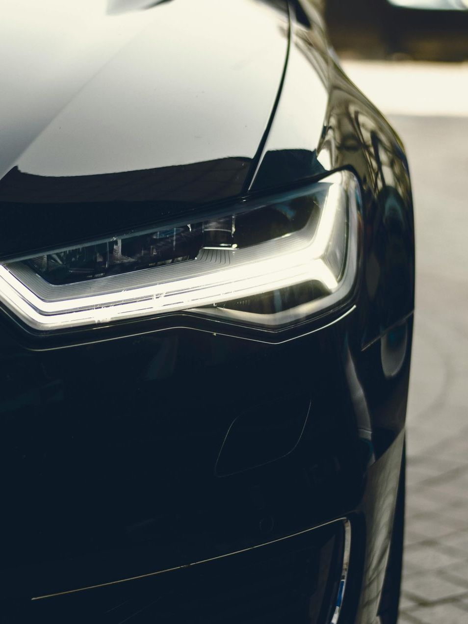 A close up of a black car 's headlight