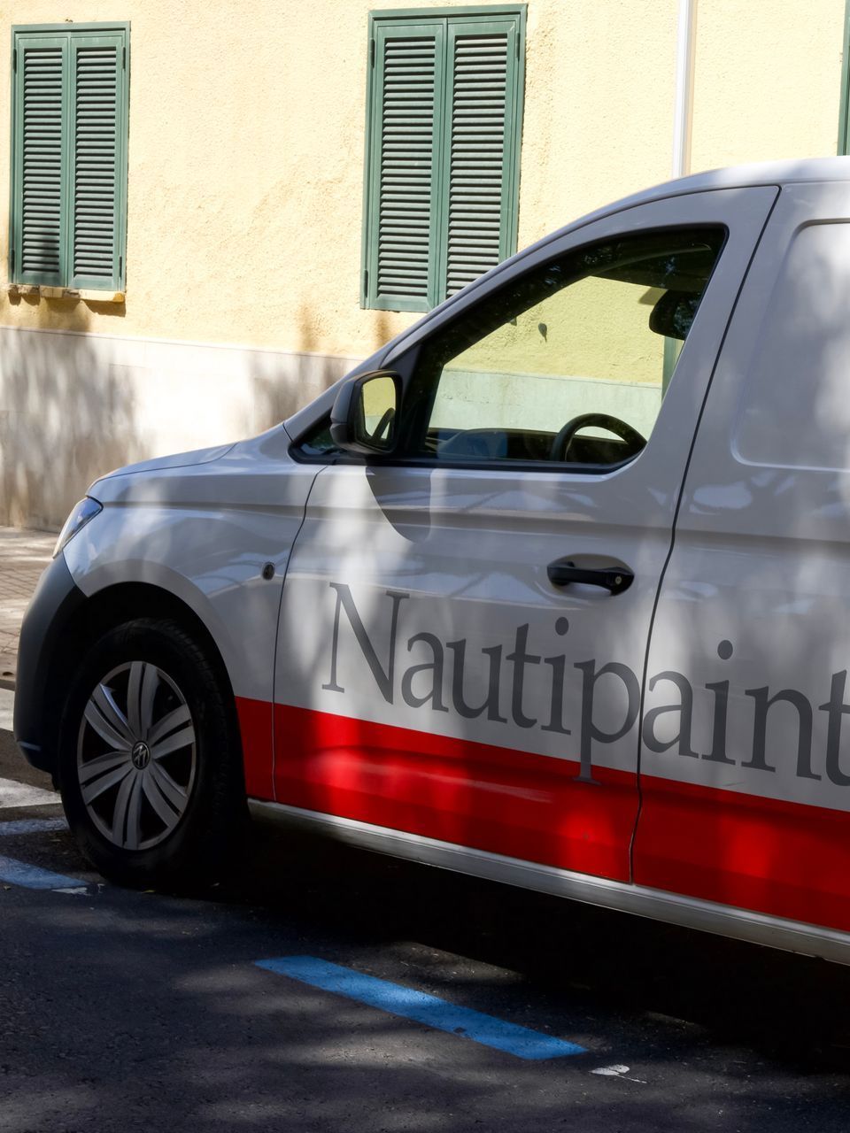A white and red van with the word nautipaint on the side