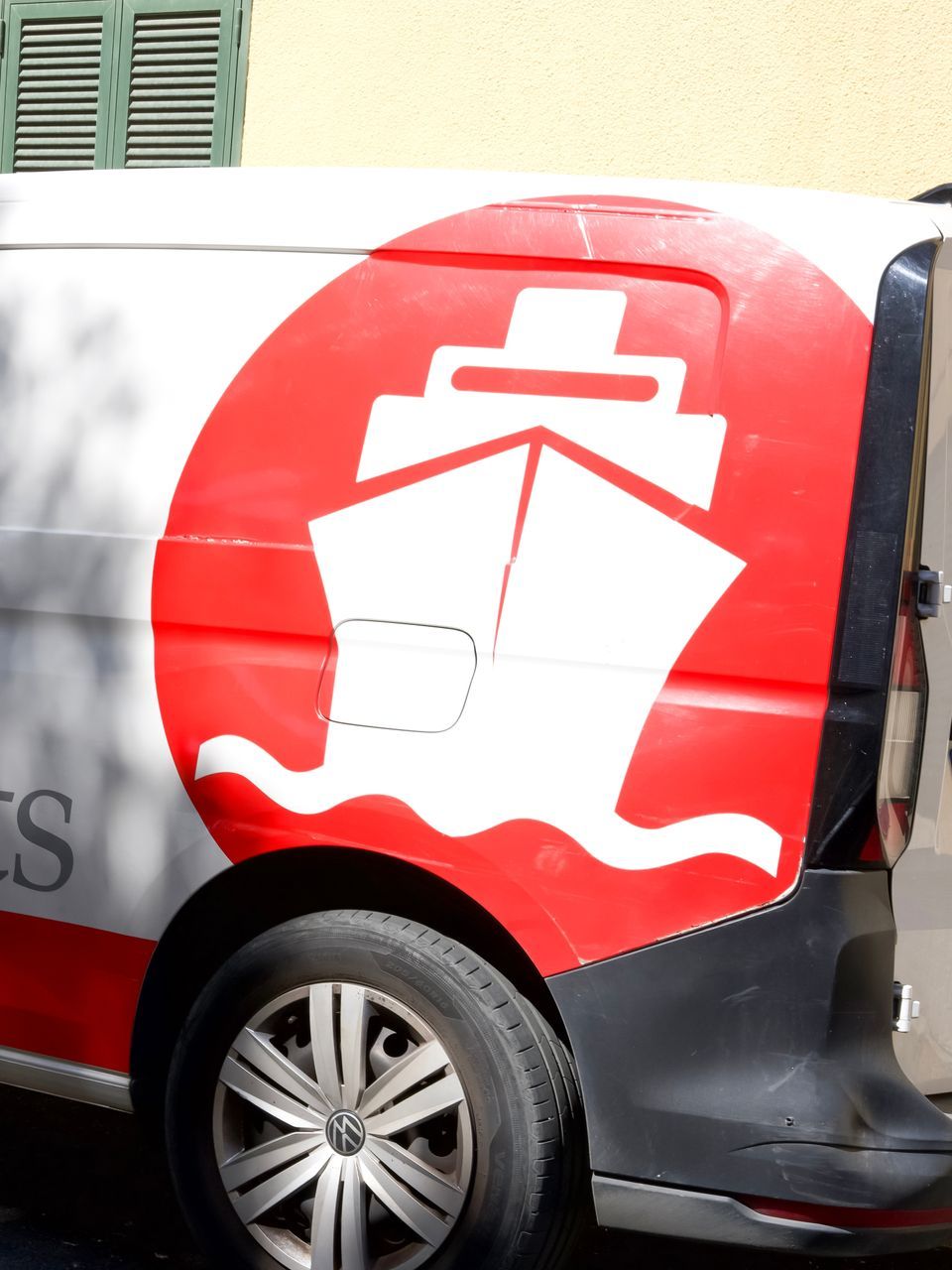 A red and white van with a ship on the side