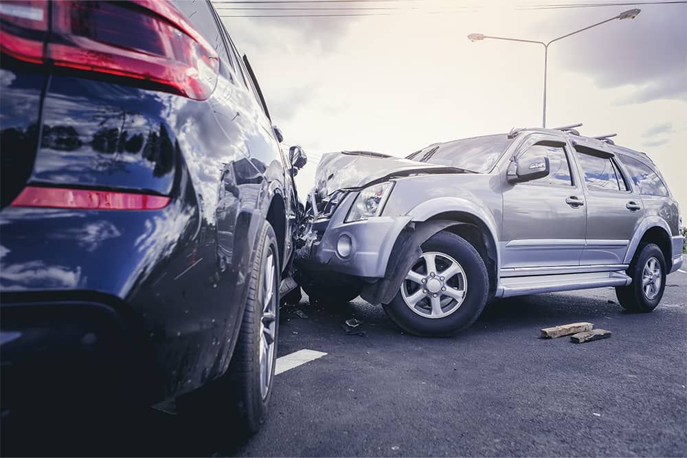 Two cars are involved in a car accident on the road.