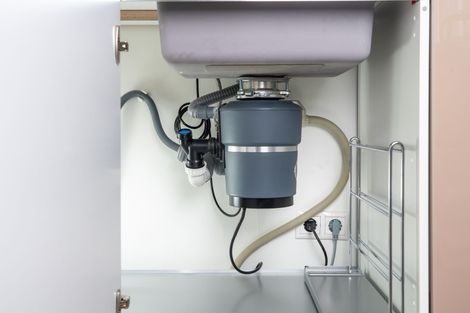 A kitchen sink with a garbage disposal underneath it.