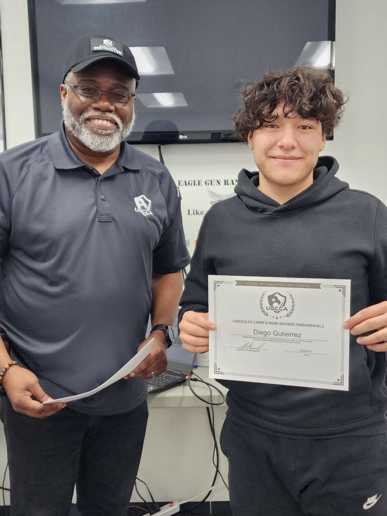 Man in cap with teen holding certificate; both smile. Setting appears to be an office.