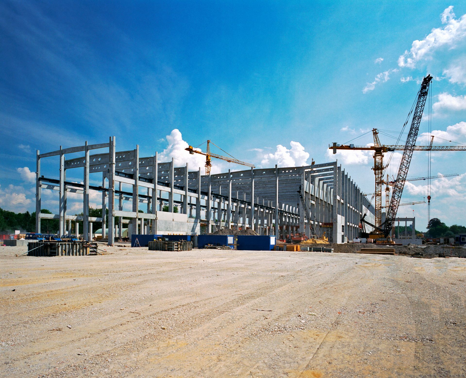 Active industrial construction site with heavy machinery building a large facility.