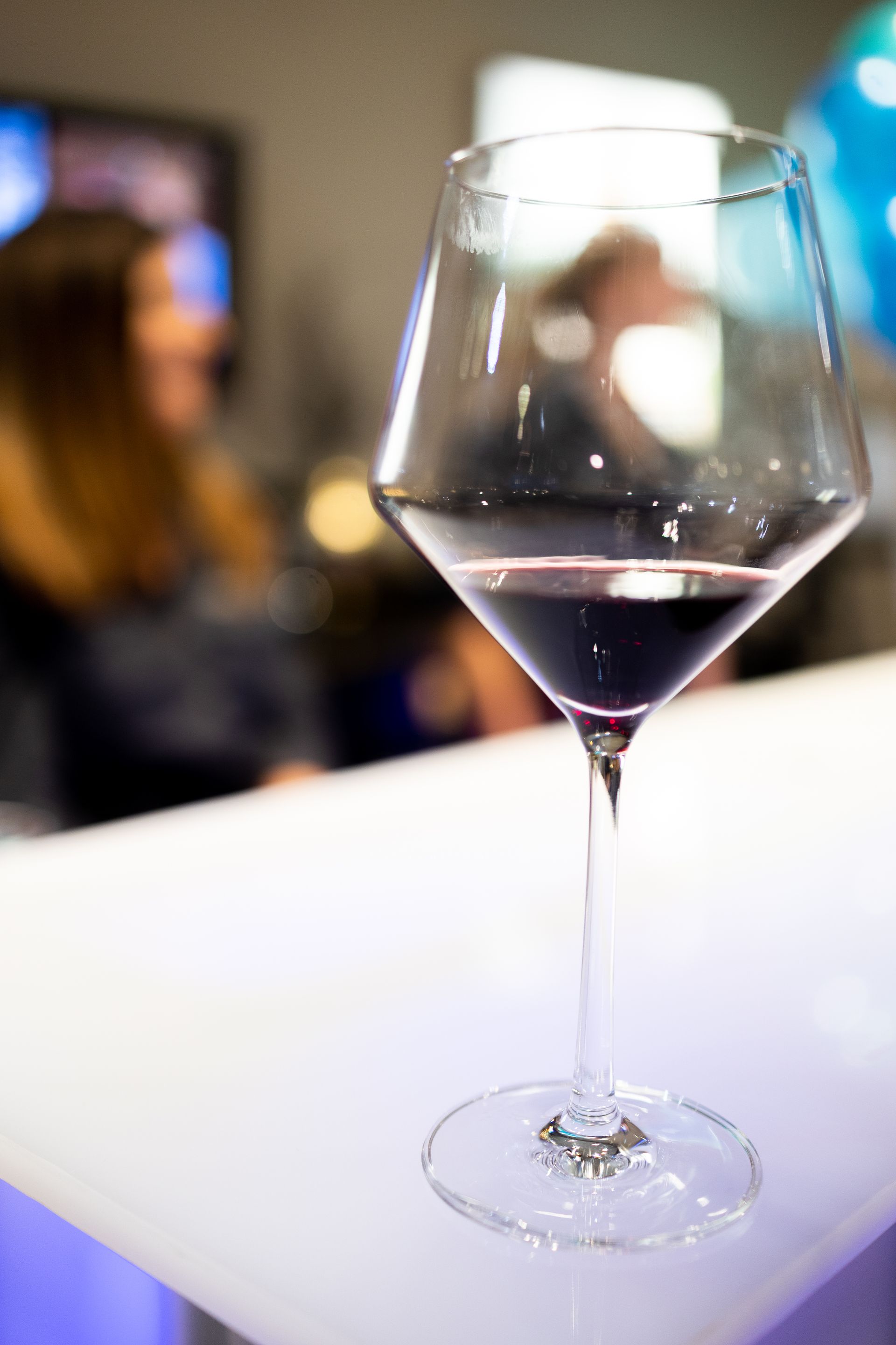 A glass of red wine is sitting on a table.