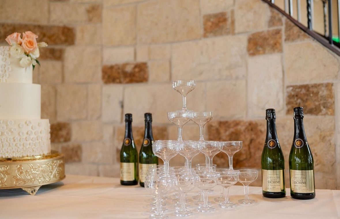 A table with bottles of champagne and a cake on it.