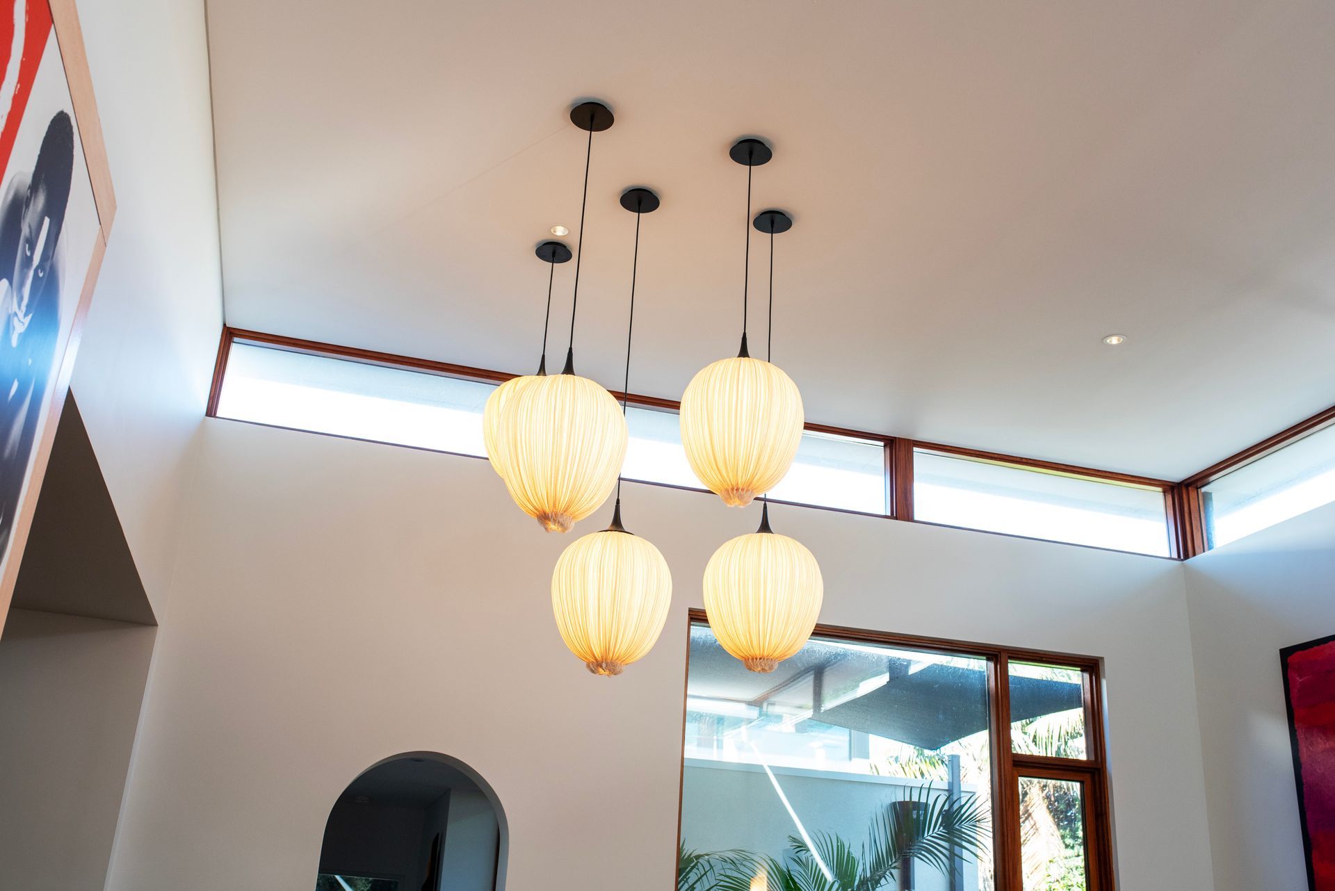 Living space with vaulted ceiling and four globe pendant lights.