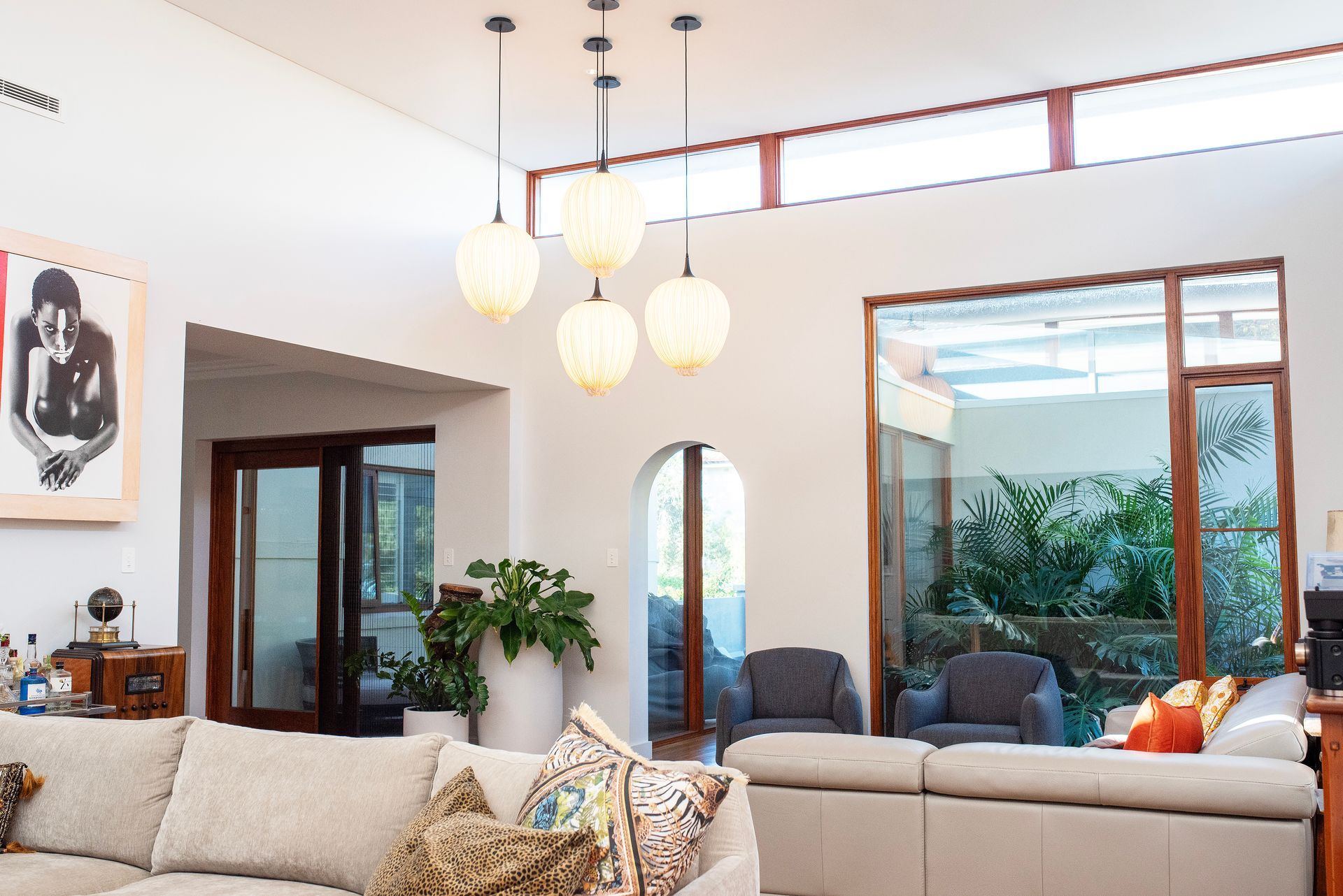 Bright living room with modern lights and garden view seating.