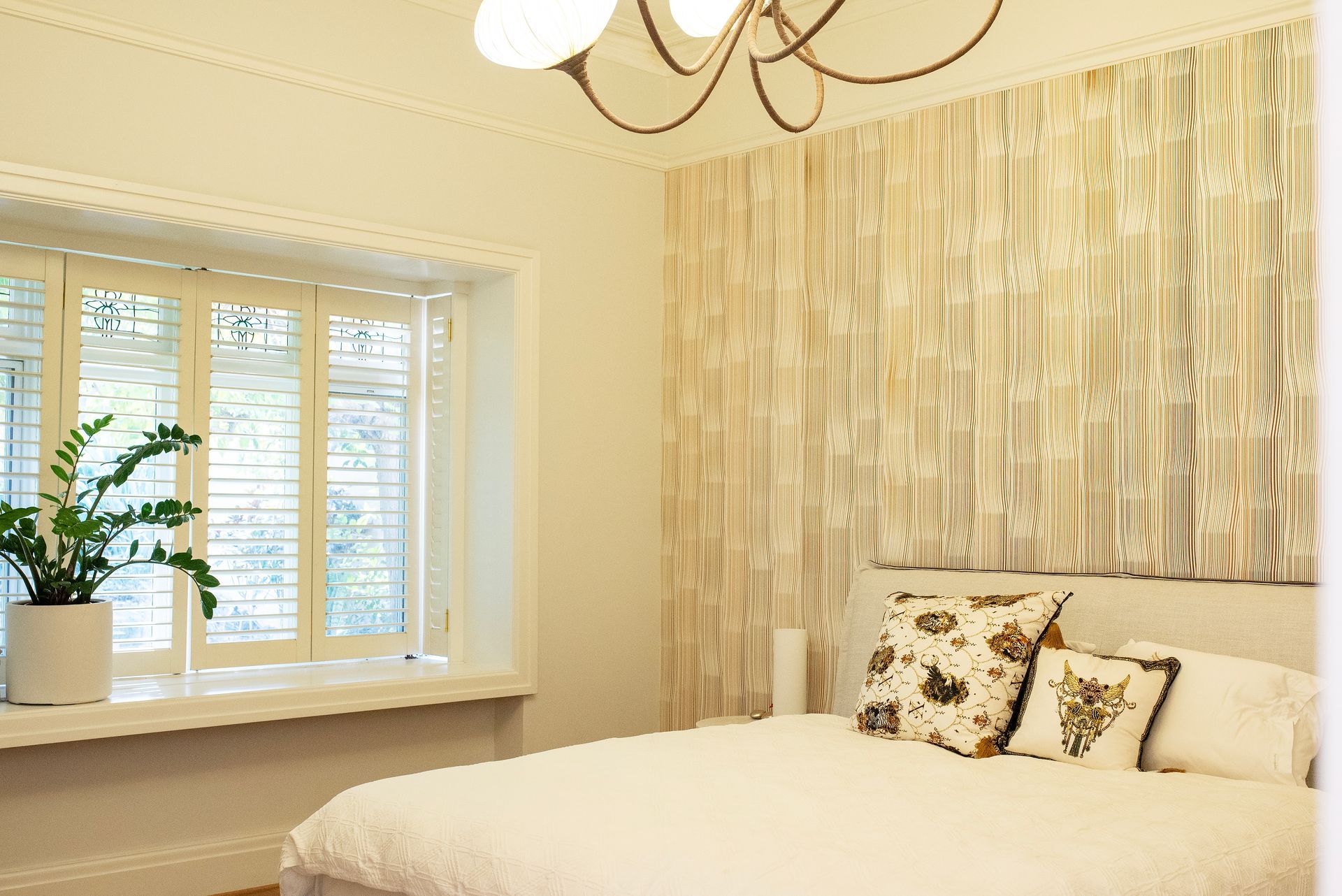 Bedroom with patterned wallpaper, large window, and double bed