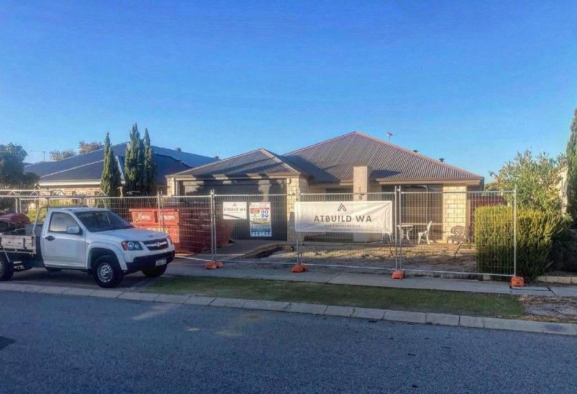 Residential home under renovation with construction materials and a work truck outside