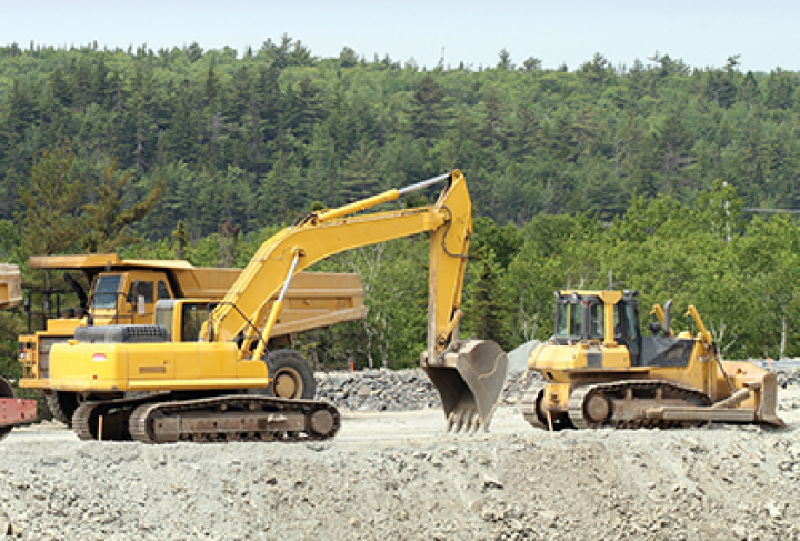 A bulldozer and an excavator are working on a construction site.