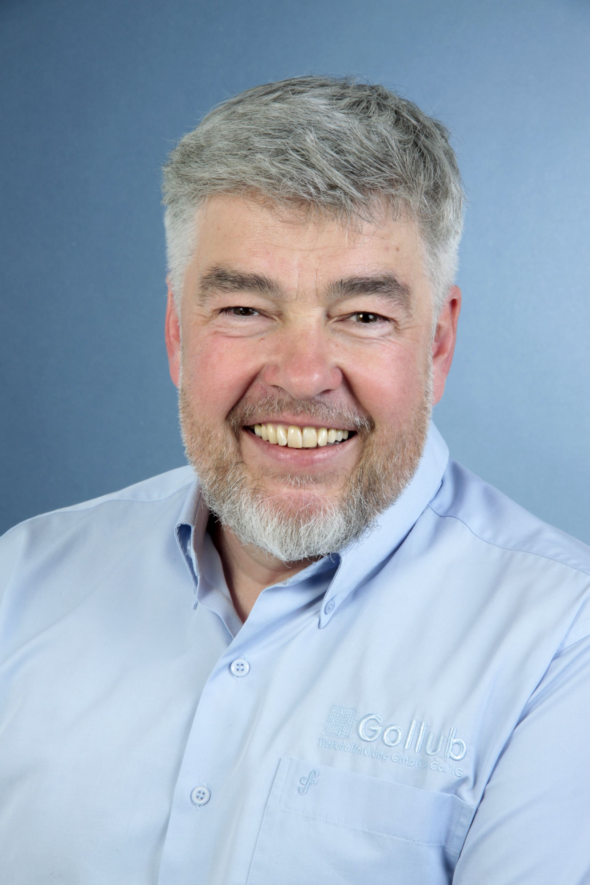 A man in a suit and tie has a name tag that says gelko