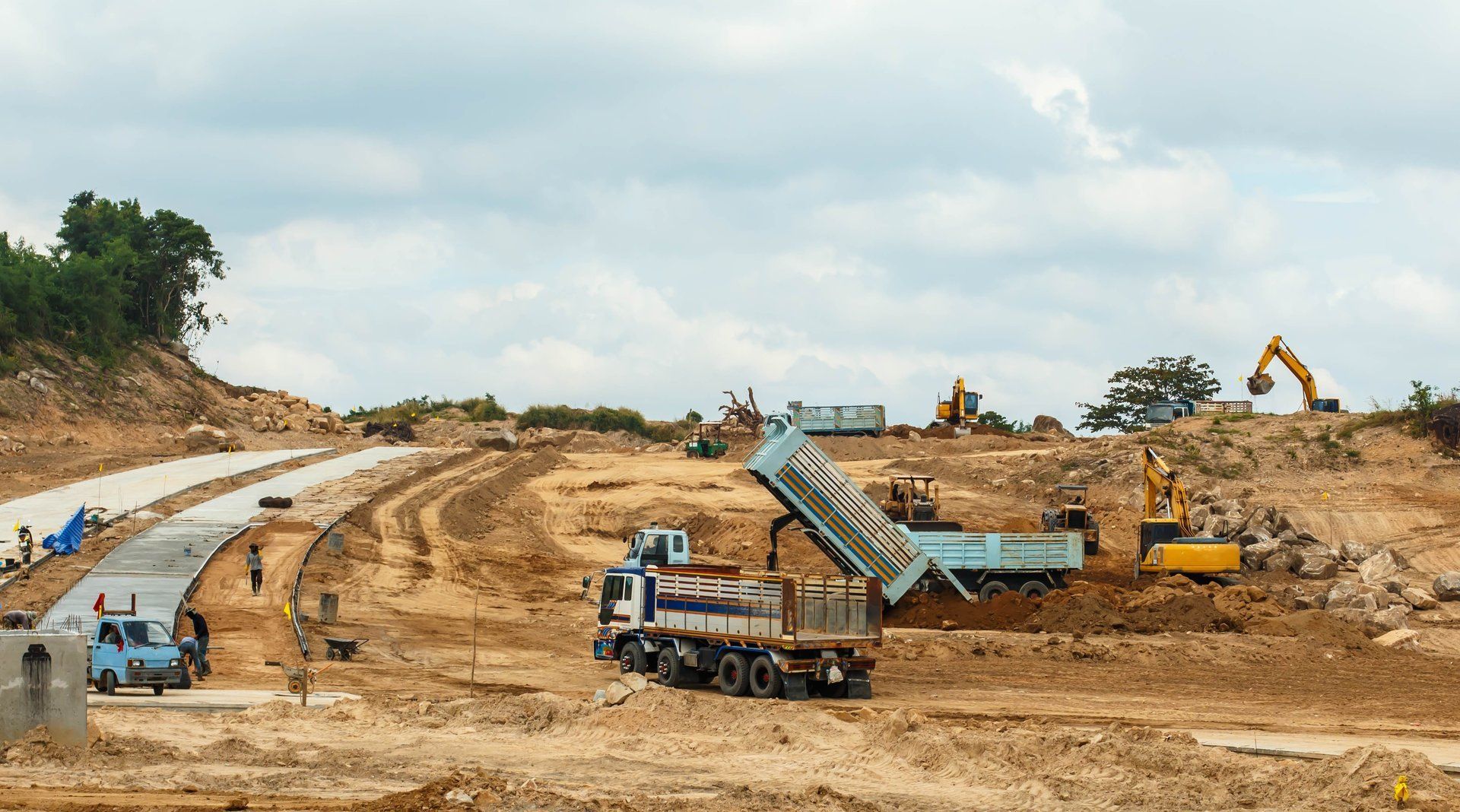 A dump truck is being loaded with dirt at a construction site.