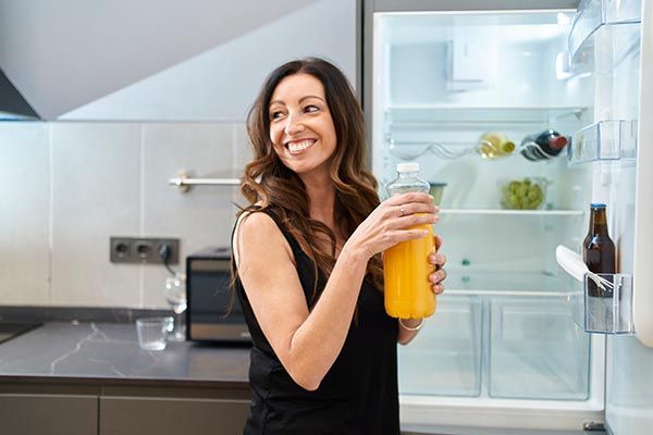 Woman Taking Bottle of Juice from Refrigerator — Lubbock, TX — Wolfforth Appliance Service