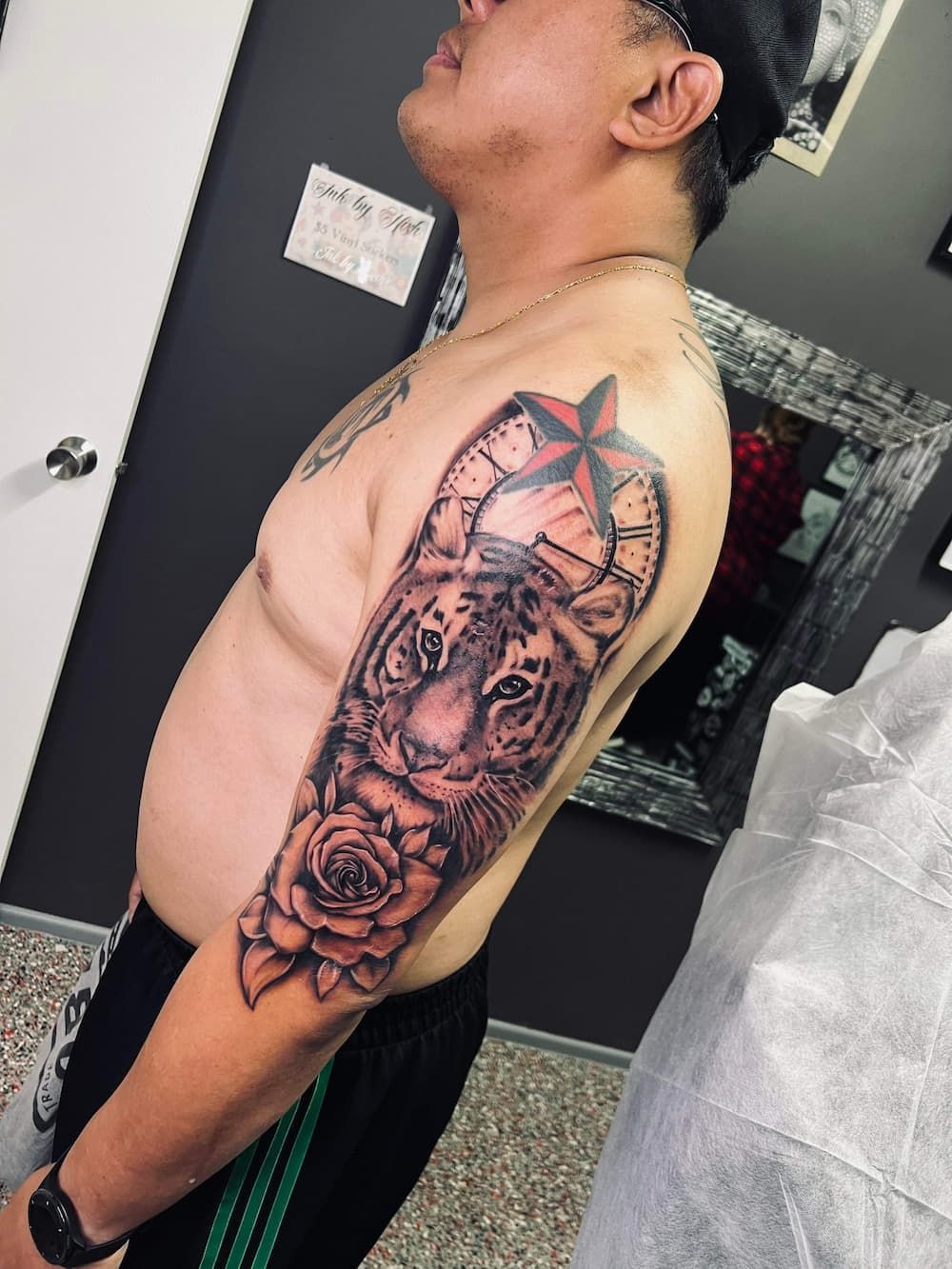a man has a tattoo of a tiger and roses on his arm - Tattoo Studio in Kawana, QLD