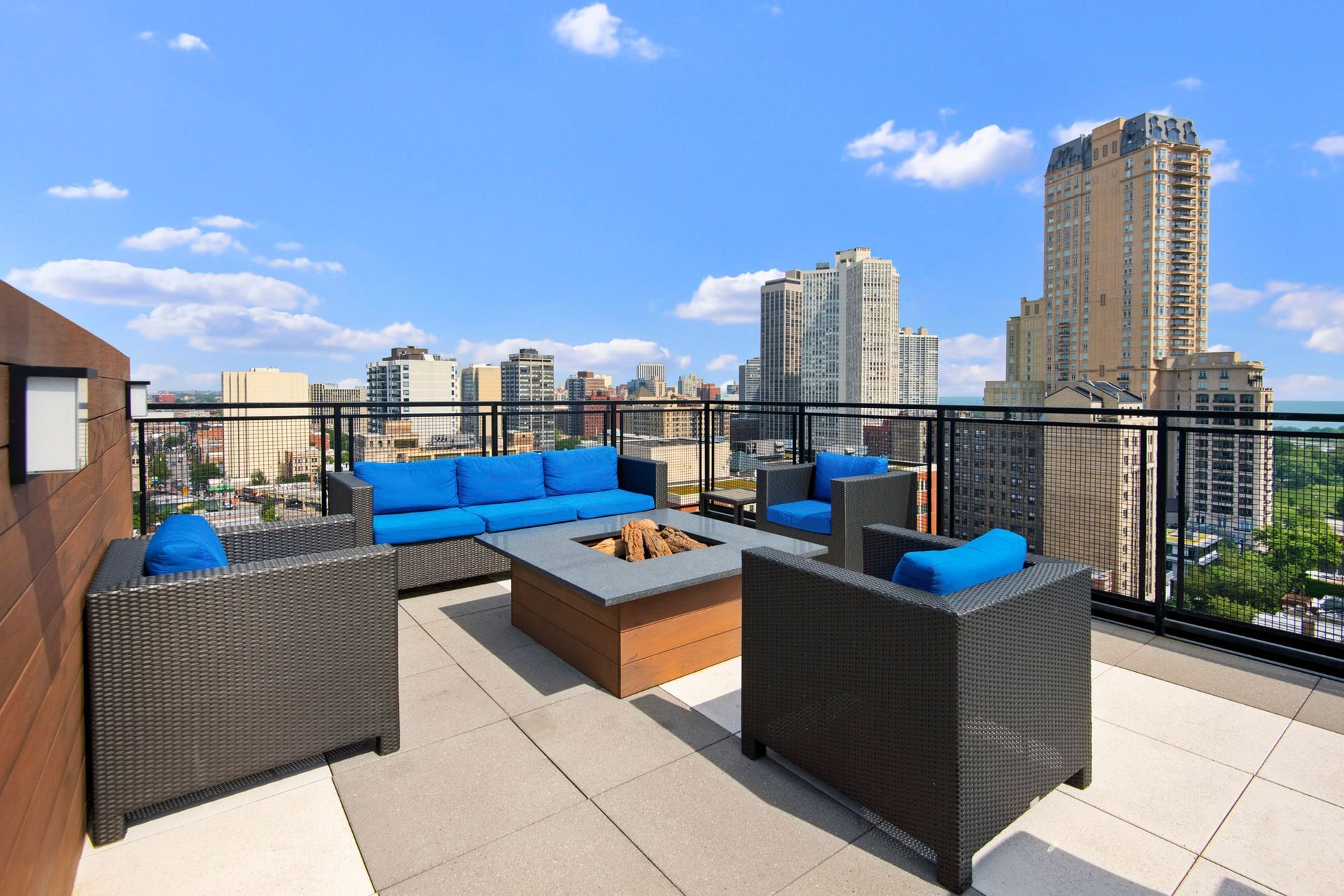 A rooftop patio with a fire pit and a view of the city at Park Lincoln by Reside.