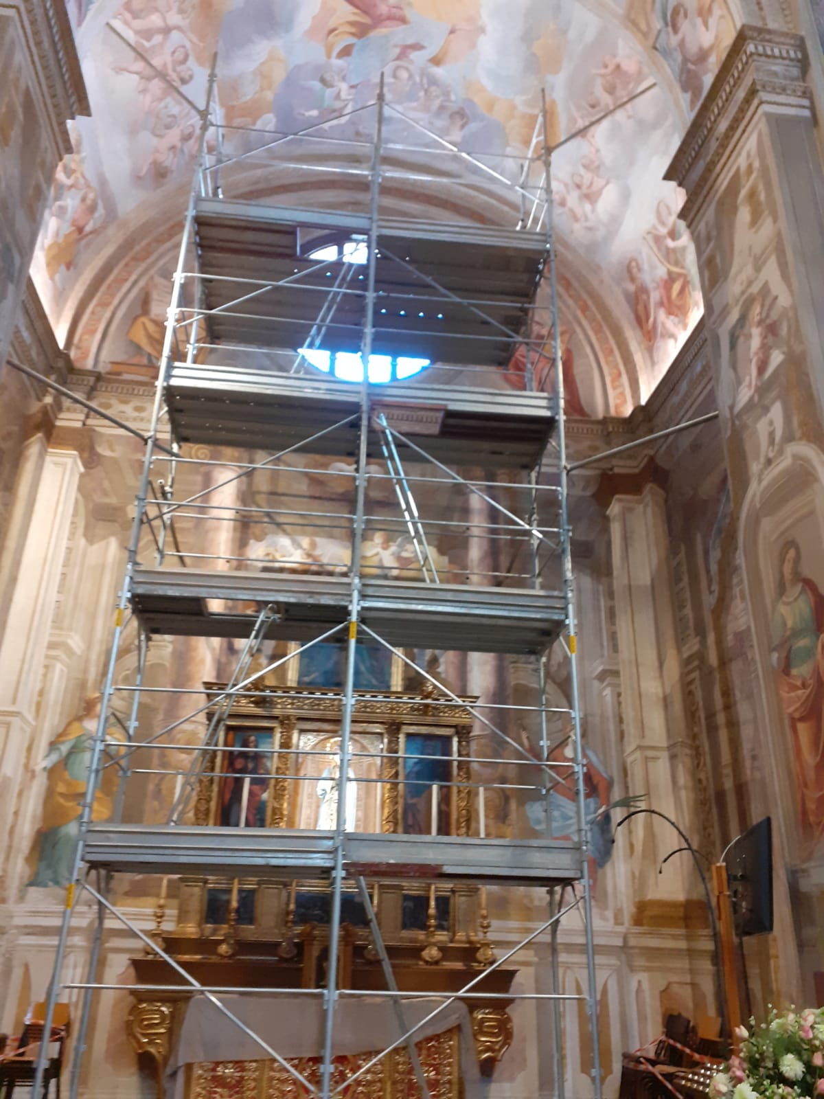 Impalcature in chiesa, sopra l'altare dorato, sotto il soffitto dipinto. Lavori in corso sugli affreschi.