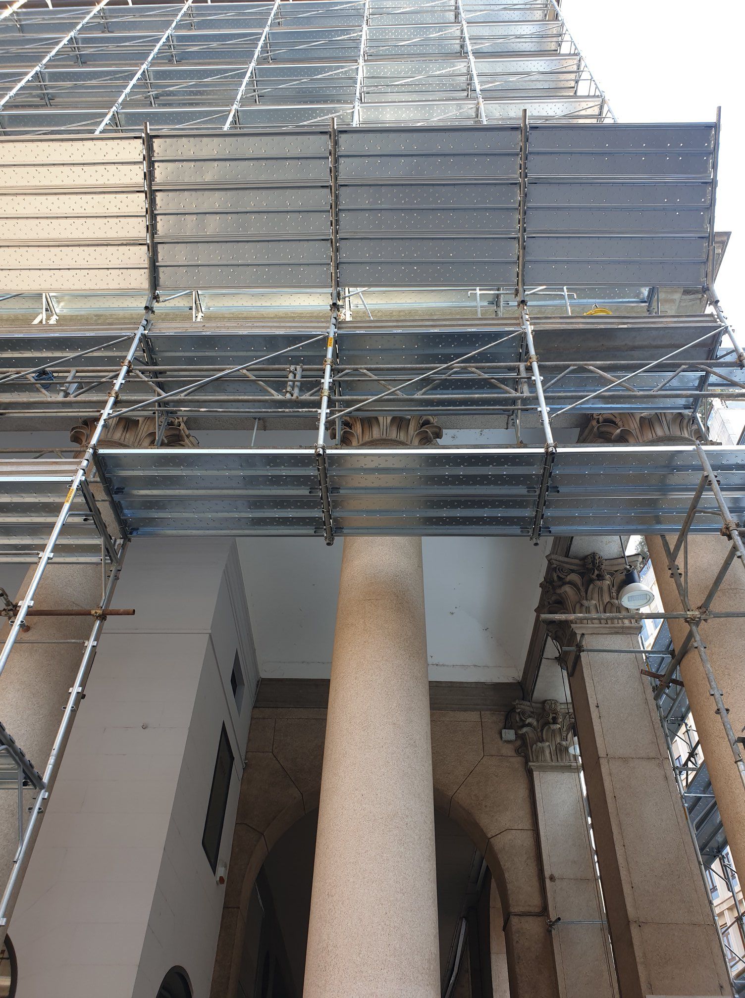Impalcatura sulla facciata dell'edificio con colonna alta, probabilmente in fase di ristrutturazione.