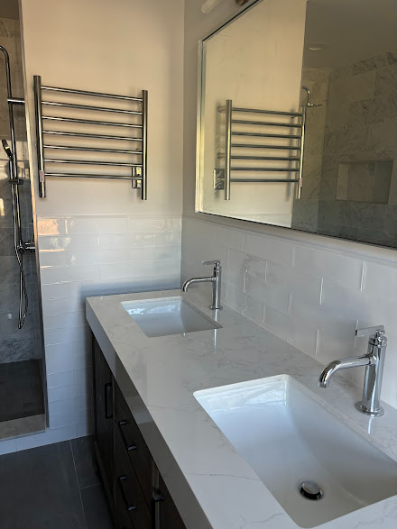 A bathroom with two sinks and a shower.