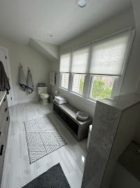 A bathroom with a toilet , sink , and window.