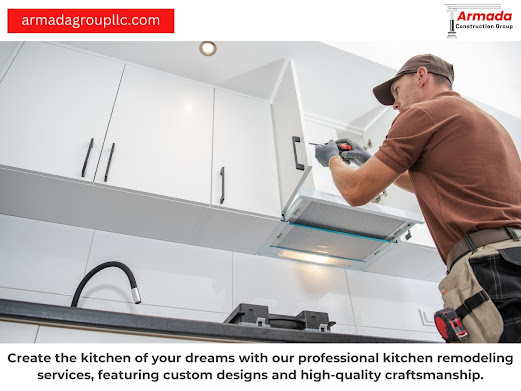 A man is working on a kitchen cabinet with a drill.