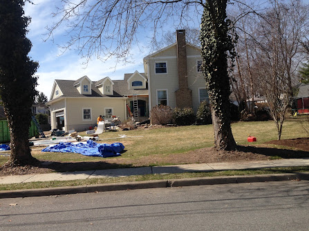 A house with a lot of blue tarps in front of it