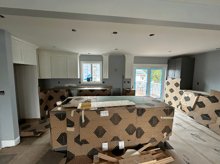 A kitchen under construction with a lot of cardboard boxes on the floor.