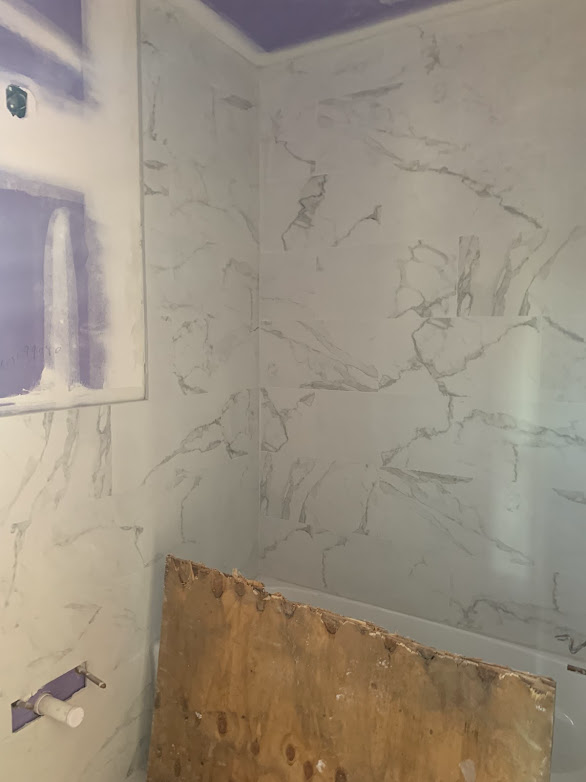 A bathroom with marble walls and a purple ceiling.