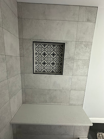 A bathroom with a shelf and a niche in the wall.