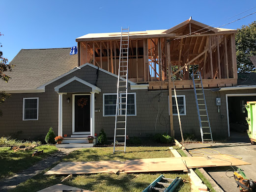 A house that is being remodeled with a ladder in front of it