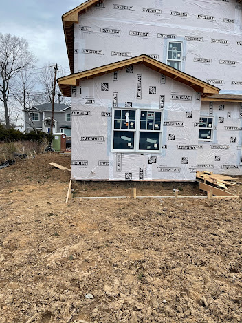 A house is being built in the middle of a dirt field.