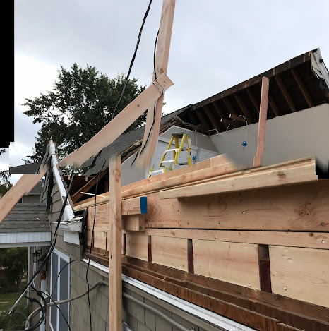 A ladder is on the roof of a house under construction