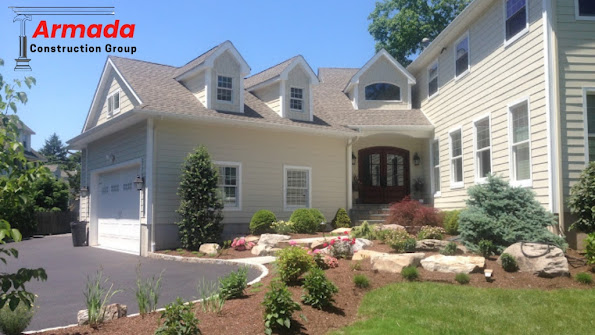 A large house with a sign that says ' armada construction group ' on it