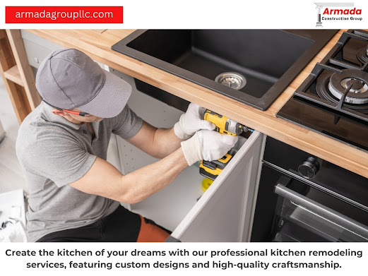 A man is working on a kitchen sink with a drill.