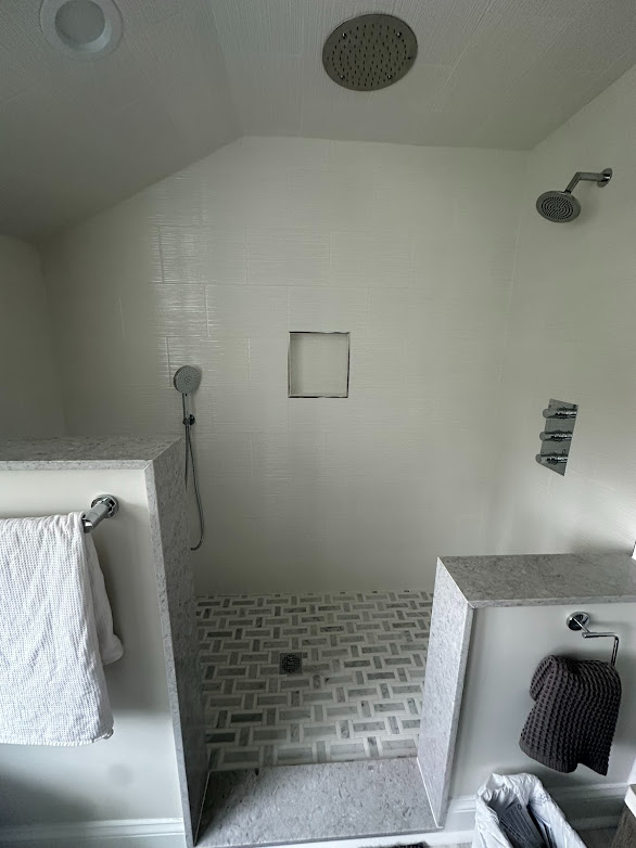A bathroom with a walk in shower and a shower head