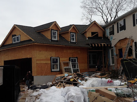 A house under construction with a lot of snow on the ground